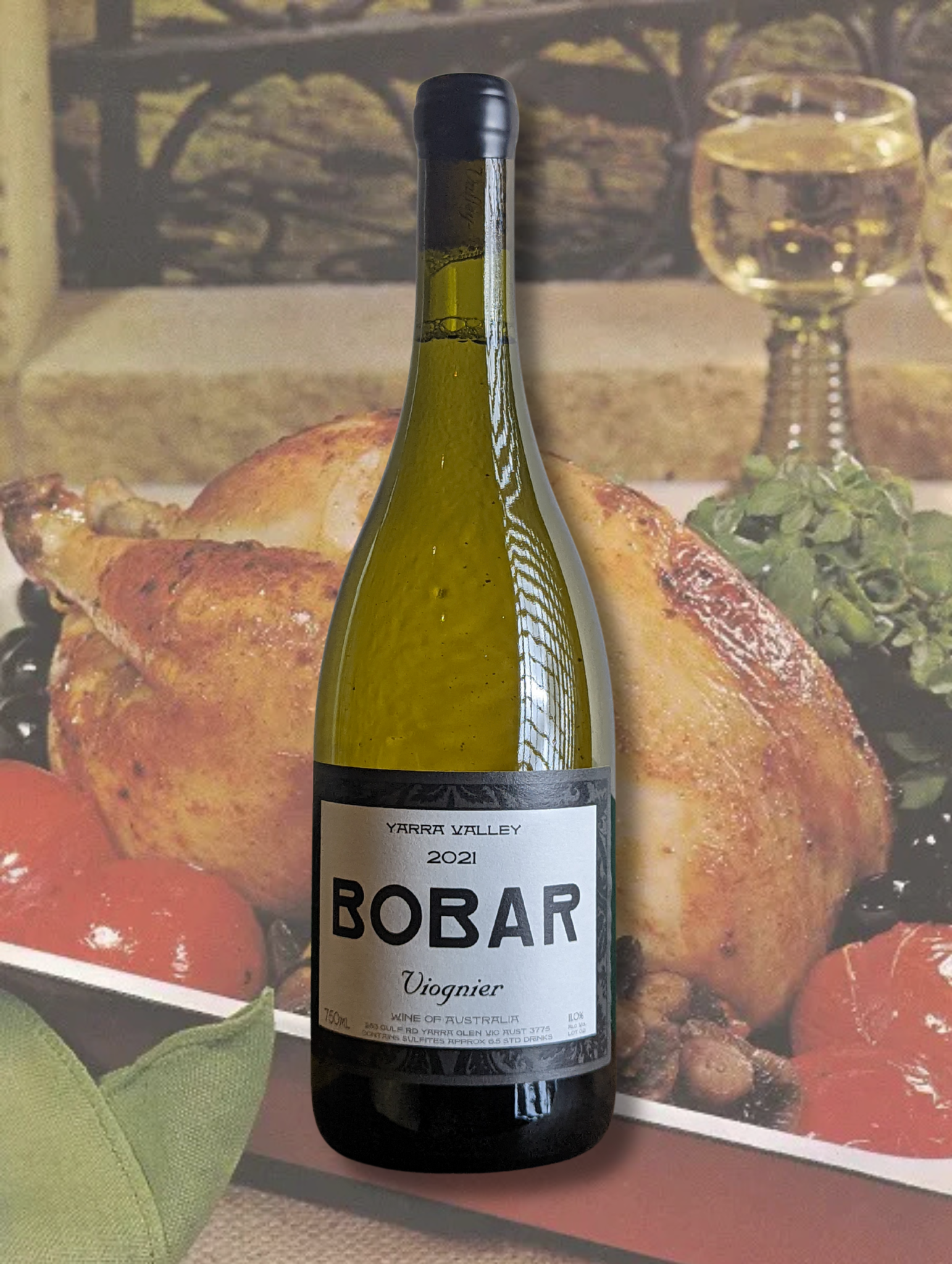 Bottle of Bobar Wines 2023 Viognier on a background of a vintage cookbook picture for roast chicken. 