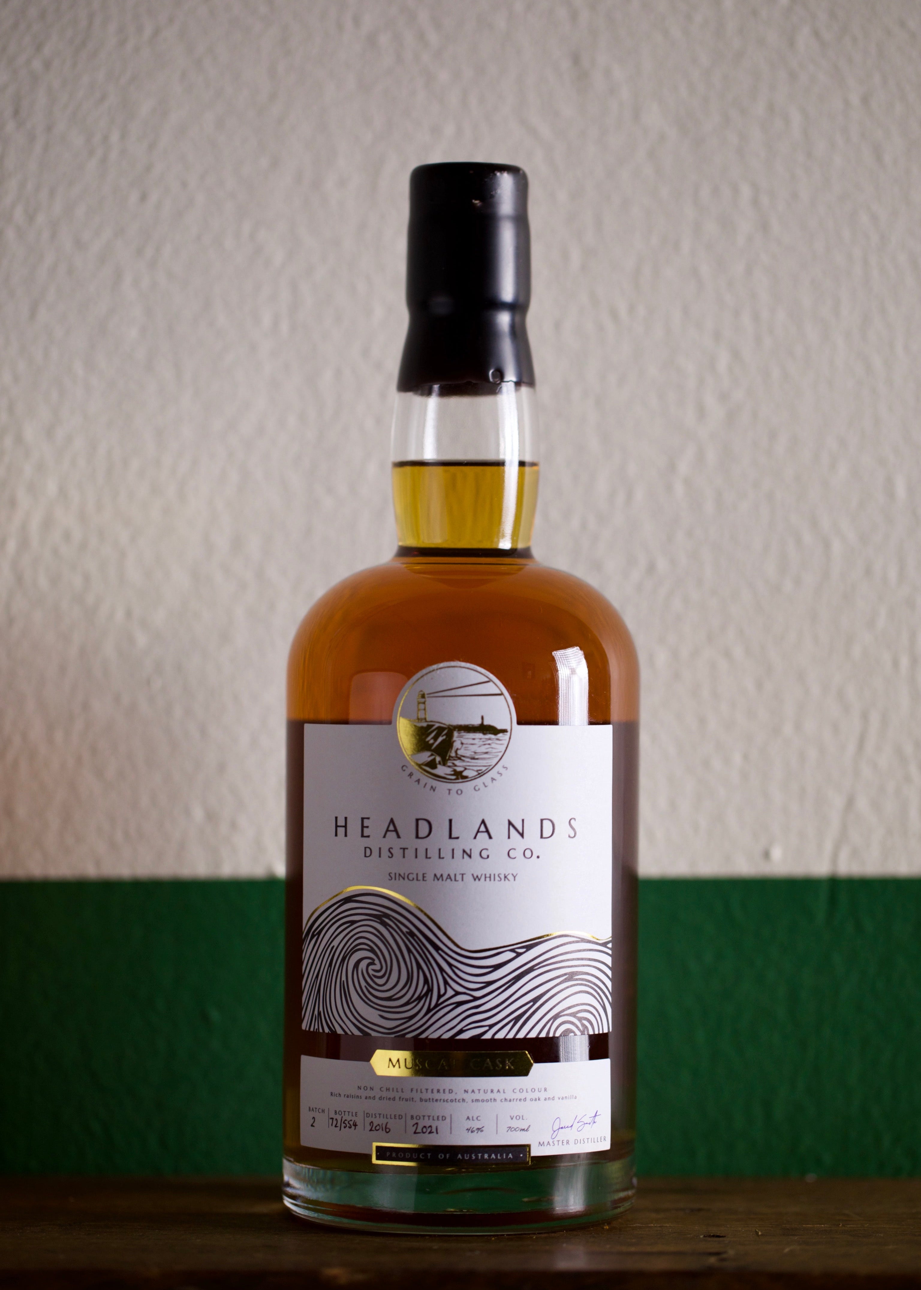 A bottle of Headlands Distilling Co. Muscat Cask Australian Single Malt Whisky with a clear label and cap, displayed against a neutral background.